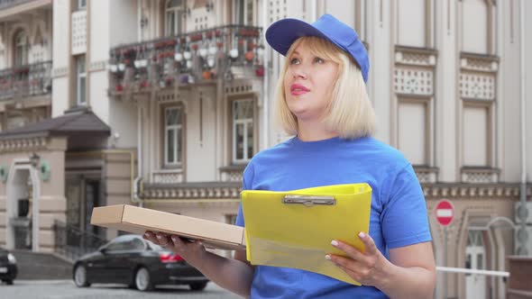 Friendly Pizza Delivery Woman Smiling To the Camera While Working in the City alt