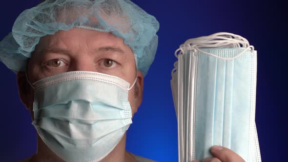 Portrait of Doctor in Surgical Face Mask Holding Lot Medical Disposable Face Protection Bandage