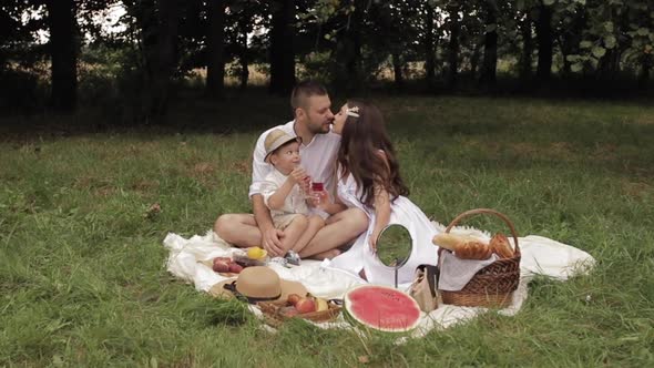 Son Feeding His Mother with Cherry in Park.