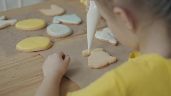 Little Girls Draws Icing on Cookies