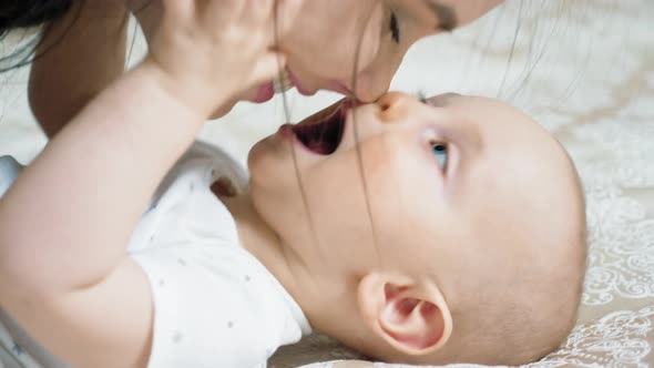 Young Mother Lying in Bed with Her Newborn Baby Boy alt