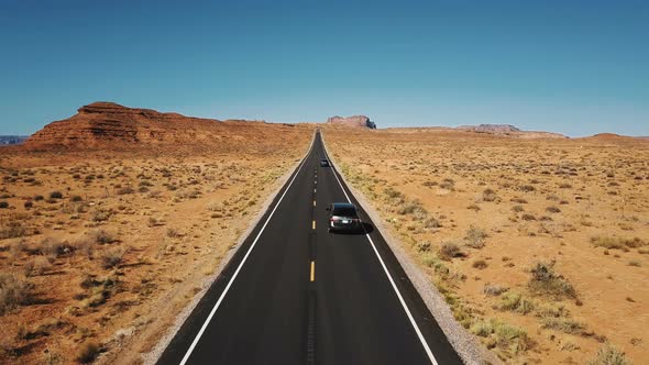 Drone Follows Two Cars Driving Along Beautiful Highway Road Monuments Valley, Wide Open Endless Dry alt