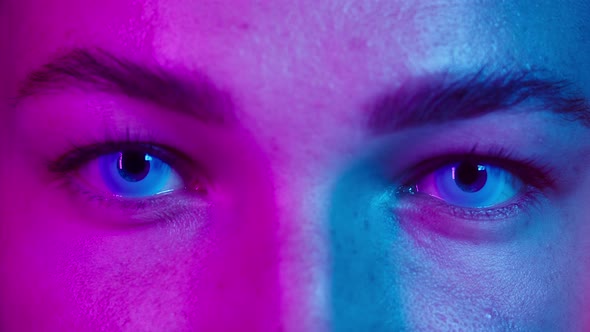 Closeup of Young Woman Eyes Wearing Blue Decorative Lenses in Ultraviolet Light alt