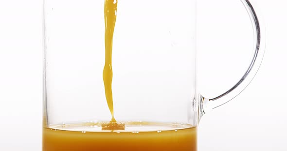 Orange Juice being poured into Glass against White Background, Slow Motion 4K alt