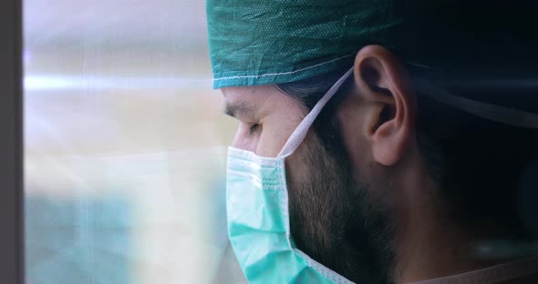 Tired Doctor or Nurse is Watching from a Window alt