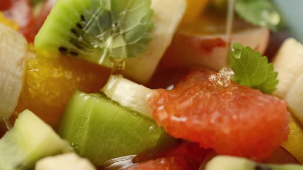 Close-up of a bowl of fruit salad with honey poured on it