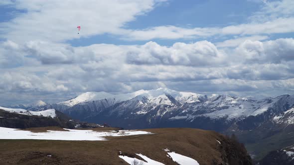 Caucasus mountains. Paraglider flies among the snow-capped mountains.