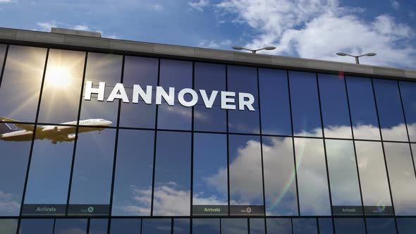Airplane landing at Hannover Germany airport mirrored in terminal alt