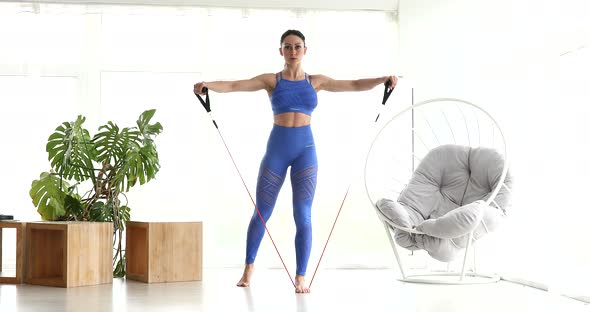 Woman during her fitness workout at home with rubber band.