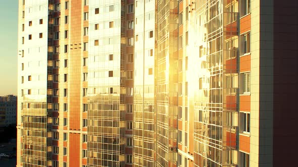An Amazing Surreal Ascent Aerial Flight Along a Glittering Glass Apartment Building in the Sunlight