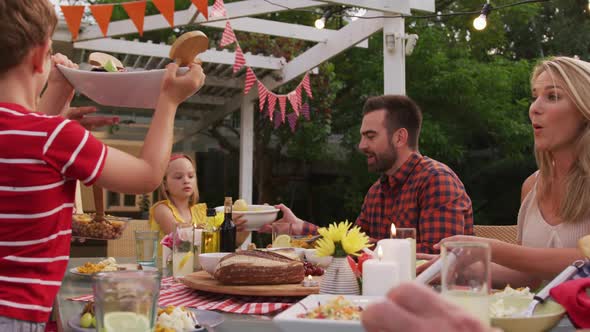 Three generation family enjoying lunch outdoors alt