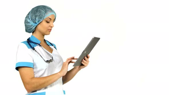 Young Female Medical Nurse Using Tablet Computer on White Background. alt