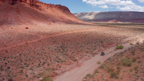 Wide aerial shot of dune buggy driving through Utah's Hurricane Valley. alt