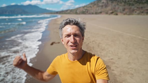 Close Up Selfie Portrait of Happy Middle Aged Greyhead Man at Sea Coast Enjoys Sunny Day on alt