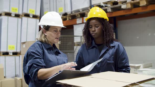 Focused Diverse Female Worker Talking in Warehouse alt
