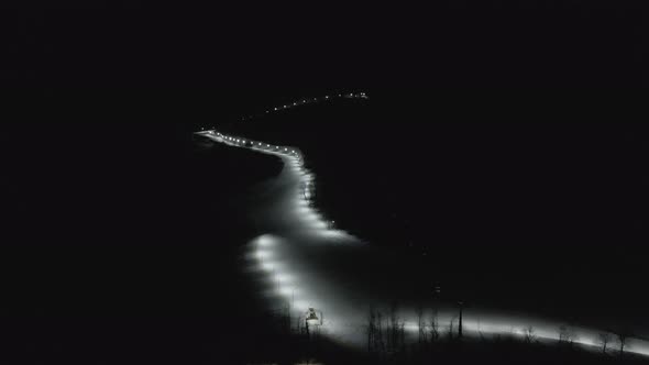 Flying at night over rope-way with gondolas at mountain resort Crystal Park in Bakuriani.  alt