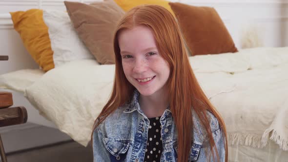 Teenage Girl Looking at Camera and Smiling at Home alt