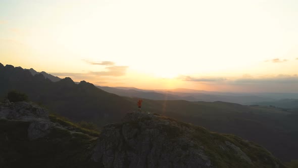 Mountain Hiker with Backpack on Mountain Peak with Breathtaking Hills Panoramic View at Sunset alt