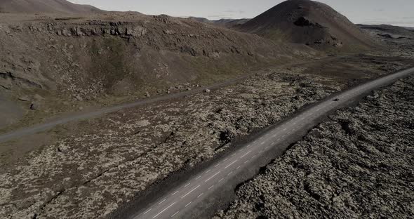 Car Driving on Road Going Through Lava Field in Iceland alt