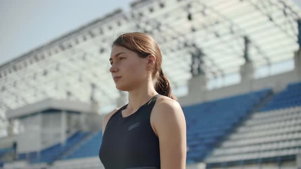 Side View of a Group Female Athlete Starting Her Sprint on a Running Track. Runner Taking Off From alt