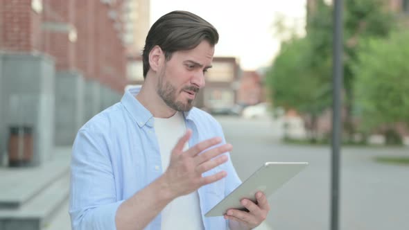 Portrait of Man Having Loss on Tablet Outdoor alt