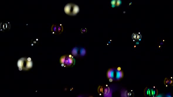 Floating Soap Bubbles in the Air Close Up. Slow Motion. Black Backgroungs alt