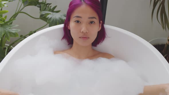Portrait of Beautiful Asian Woman Lying in Bathtub alt