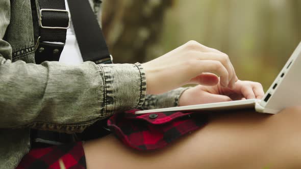 Young Woman Unrecognizable Tourist Using Laptop in the Park. Close Up alt