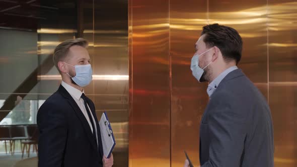 Two Businessmen Avoid a Handshake When Meeting and Greet with Elbows Bumping alt