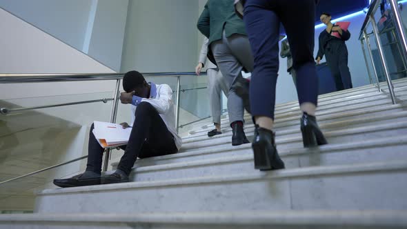 Busy Business People Passing Stressed Overwhelmed African American Man Sitting on Stairs with alt