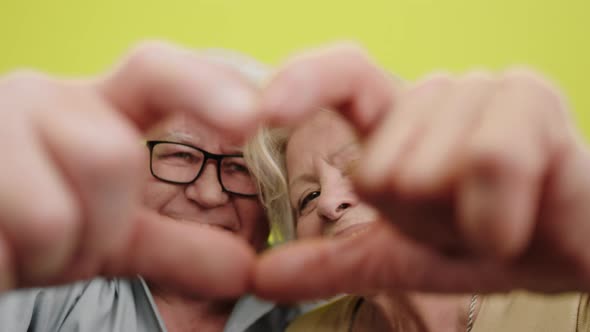 Happy Large Smiling Old Couple Make a Heart From alt