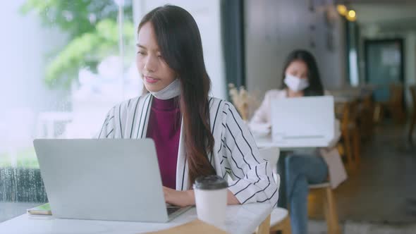 Asian attractive beautiful woman with face mask sitting at table near window alt