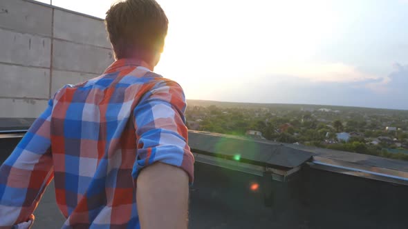 Guy Holds Hand of His Boyfriend and Runs To Edge of Roof To Admire the View alt