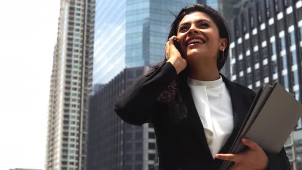Happy young indian businesswoman using her cellphone for calling