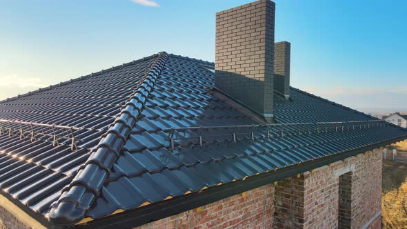 Closeup Snow Guard for Safety in Winter on House Roof Top Covered with Ceramic Shingles alt