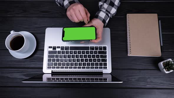 An Overhead View of the Girl's Hands Holding a Smartphone with a Green Screen and a Chrome Key alt