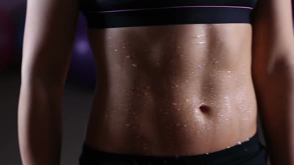 Wet Belly of Sportive Woman Covered With Water Drops, Active Training in Gym alt