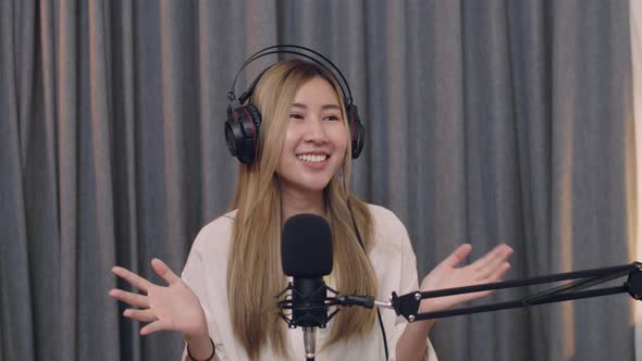 Smiling of Young Asian woman influencer recording a vlog using podcast microphone.