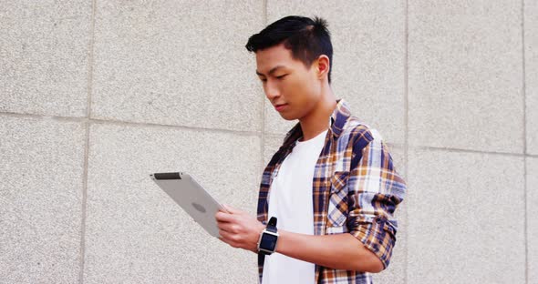 A man reading something on his tablet computer and laughing alt