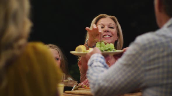 Happy family eating dinner together. alt