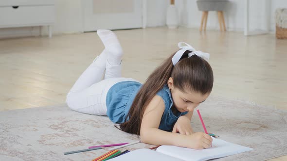 Spanish Spaniard Caucasian Little Small School Girl Daughter Child Pupil Kid Lying on Floor Draws alt