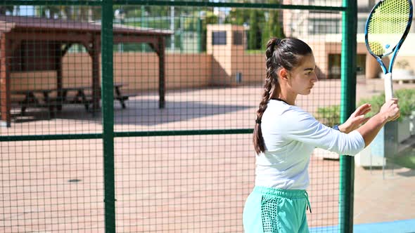 Young Woman Plays Tennis on the Field
