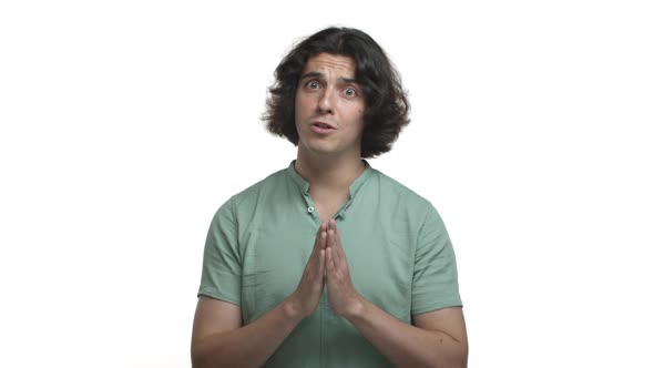 Adult Hispanic Man with Long Dark Hair Wearing Grey Shirt Pointing at you and Asking for Help alt