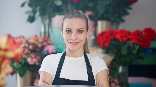 Portrait of Young Florist Female Beautiful Cheerful Woman Looks at the Camera and Smiles the alt