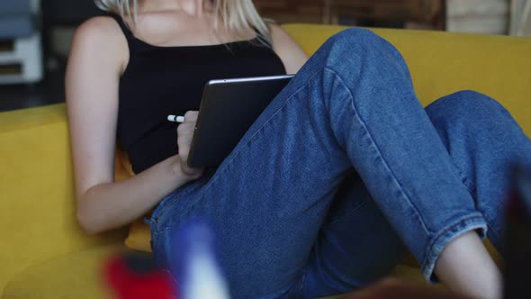 Professional Graphic Designer is Sitting Comfortably on Sofa and Drawing on Electronic Tablet alt