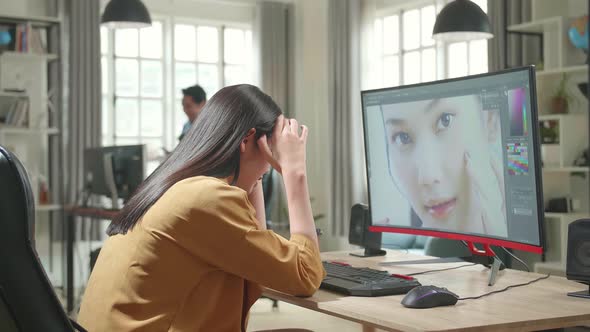 Tired Asian Female Digital Editor Works In Photo Editing Software On Her Personal Computer In Office alt