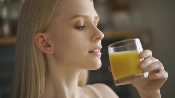 Beautiful Girl Drinking Fresh Orange Juice From Glass alt