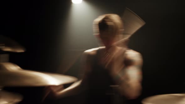 Caucasian Rock Musician Drummer with Tattoos Aggressively Plays Drums