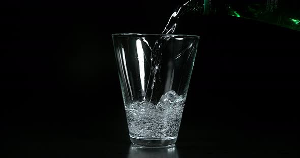 Water being poured into Glass against Black Background, Slow Motion 4K alt
