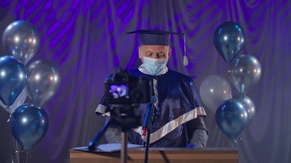Male Lecturer Wearing Medical Mask Observes Precautions Congratulate Graduates on Graduation Online alt